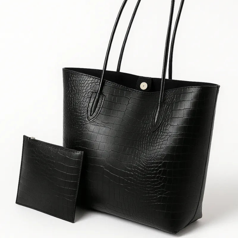 Bolsa tote preta de croco em vista frontal. A imagem exibe o acessório com a bolsinha interna removível, destacando a funcionalidade e o estilo.