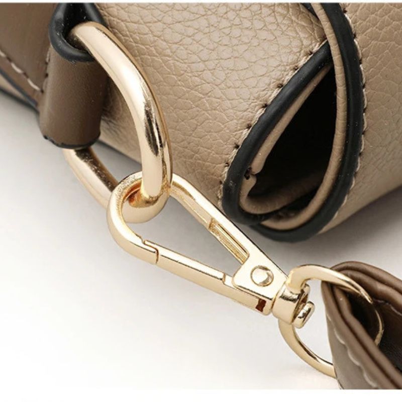 Detalhe do fechamento da bolsa transversal bege Gusure Luxuosa, destacando fivela elegante e acabamento em PU.