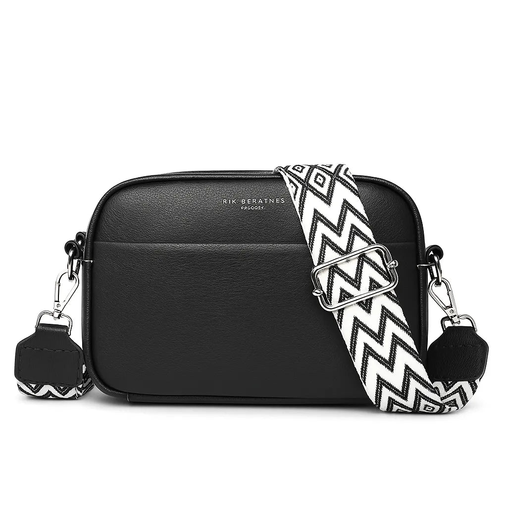 Bolsa transversal preta com alça listrada, vista frontal, destacando design moderno e couro genuíno