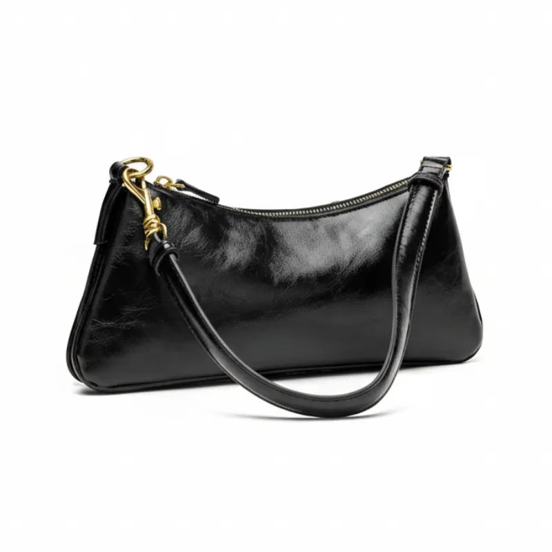 Bolsa de ombro baguete feminina preta, vista frontal em estúdio. A foto destaca o acabamento com textura estilo vintage e o design despojado.