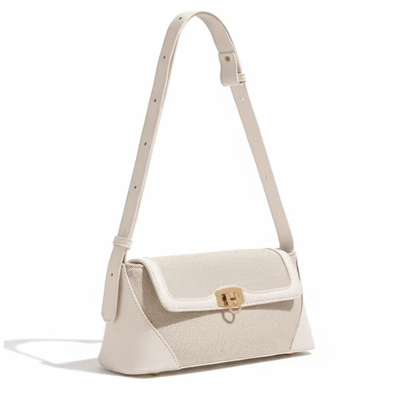 Bolsa de ombro bege canvas em vista lateral. A imagem realça a alça ajustável e a estrutura compacta do acessório.