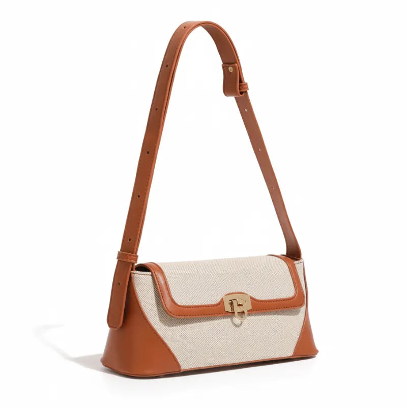 Bolsa de ombro marrom com canvas em vista lateral. A imagem realça a alça fina e o acabamento em couro nas bordas.