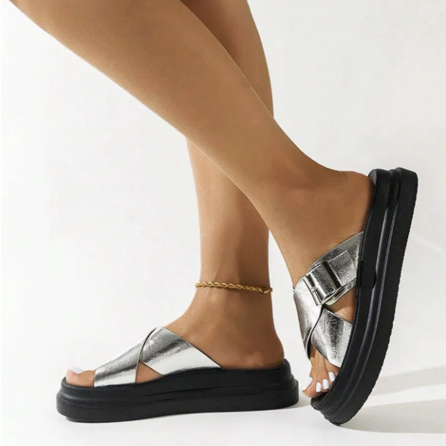 Modelo usando a papete feminina prata de fivela da Rozze, em pé. A imagem realça a praticidade do calçado e a sua combinação com diferentes estilos.