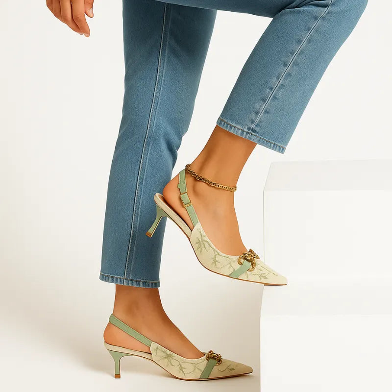 Modelo usando o scarpin Primavera Slingback com fivela Justine da Rozze. A foto de perfil enfatiza a elegância do salto alto e a estampa floral delicada.