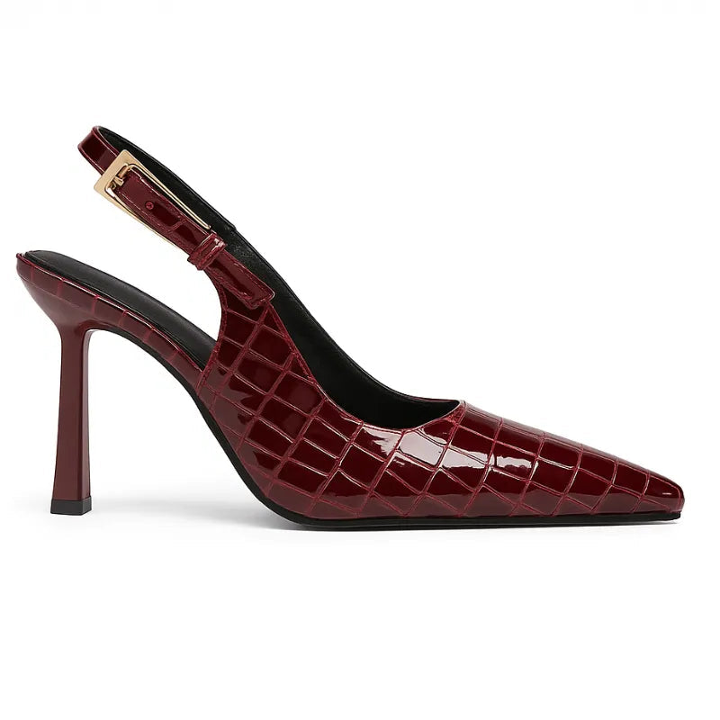 Scarpin feminino croco marsala, vista lateral. A foto em estúdio destaca o salto agulha de 9 cm, o bico fino e a alça slingback ajustável.
