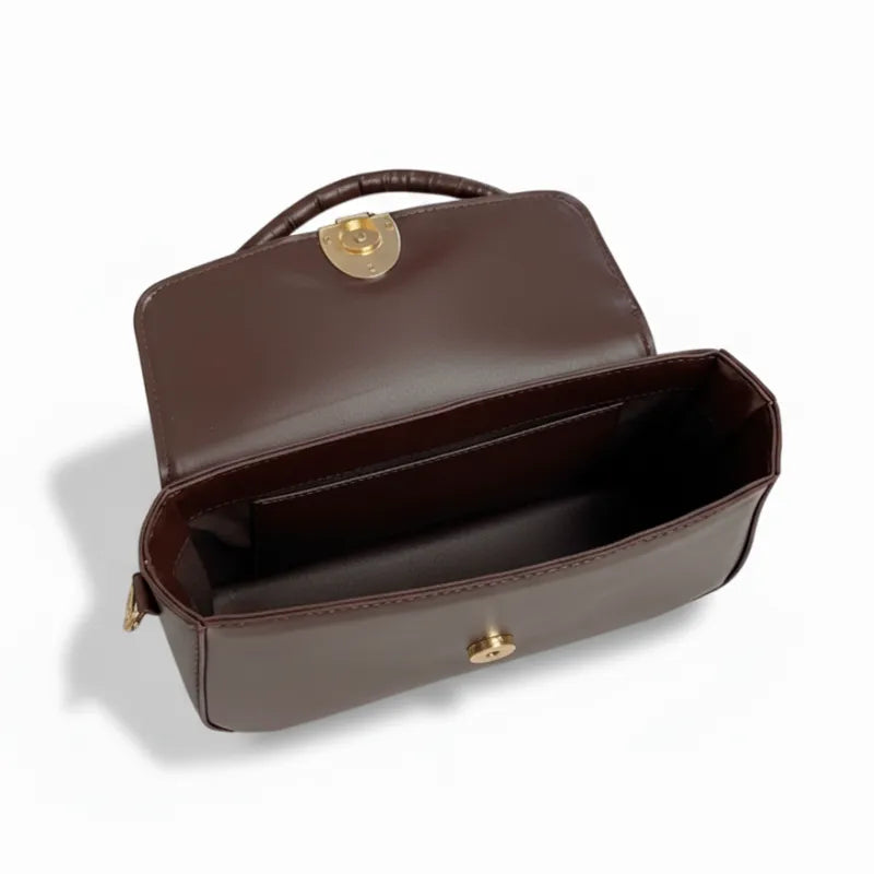 Vista superior da bolsa baguete marrom aberta. A foto revela o interior espaçoso e o mecanismo do fecho.