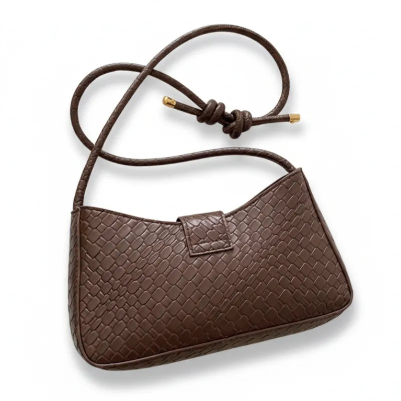 Vista superior da bolsa baguete marrom. A foto mostra o design do acessório aberto, revelando o interior.