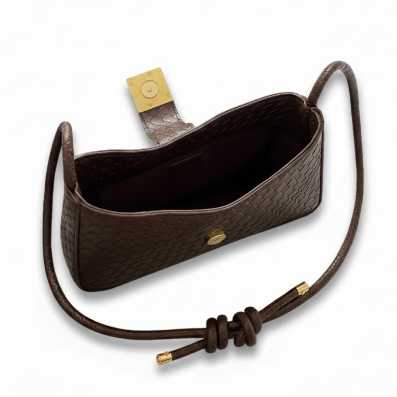 Detalhe do interior da bolsa baguete marrom e da alça ajustável. A imagem foca na funcionalidade e no acabamento.