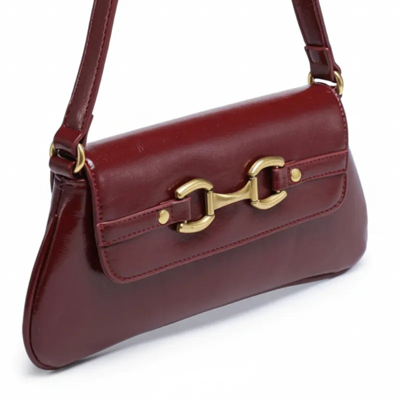 Bolsa baguete marsala em vista de ângulo. A foto em close realça o fecho exclusivo e a alça de ombro.