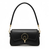 Bolsa baguete preta em vista frontal. A foto exibe a forma do acessório e o detalhe metálico na frente, que adiciona um toque sofisticado.