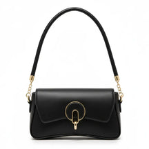 Bolsa baguete preta em vista frontal. A foto exibe a forma do acessório e o detalhe metálico na frente, que adiciona um toque sofisticado.