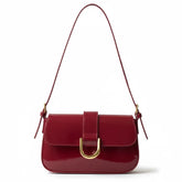 Bolsa baguete feminina vermelho verniz, vista frontal. A foto destaca o brilho do material e a fivela dourada em formato de D.