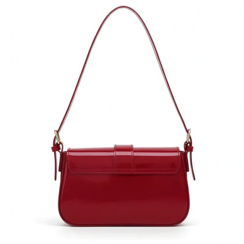 Bolsa baguete vermelha em vista traseira. A foto exibe o acabamento liso do verniz na parte de trás.