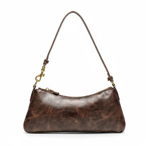 Bolsa de ombro baguete feminina marrom, vista frontal em estúdio. A foto destaca o acabamento com textura estilo vintage e a alça única com mosquetão.
