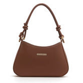 Bolsa de ombro feminina marrom, vista frontal em estúdio. A foto destaca o formato meia-lua e o detalhe de nó nas alças.