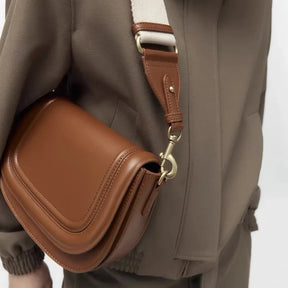 Modelo usando a bolsa de ombro Florence da Rozze. A imagem mostra o acessório em uso, com foco nas alças removíveis e no fechamento por ferrolho.
