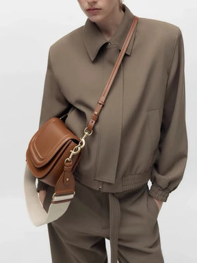 Modelo usando a bolsa de ombro Florence da Rozze, vista de perfil. A foto realça a praticidade do acessório para o dia a dia e o design que se adapta ao corpo.