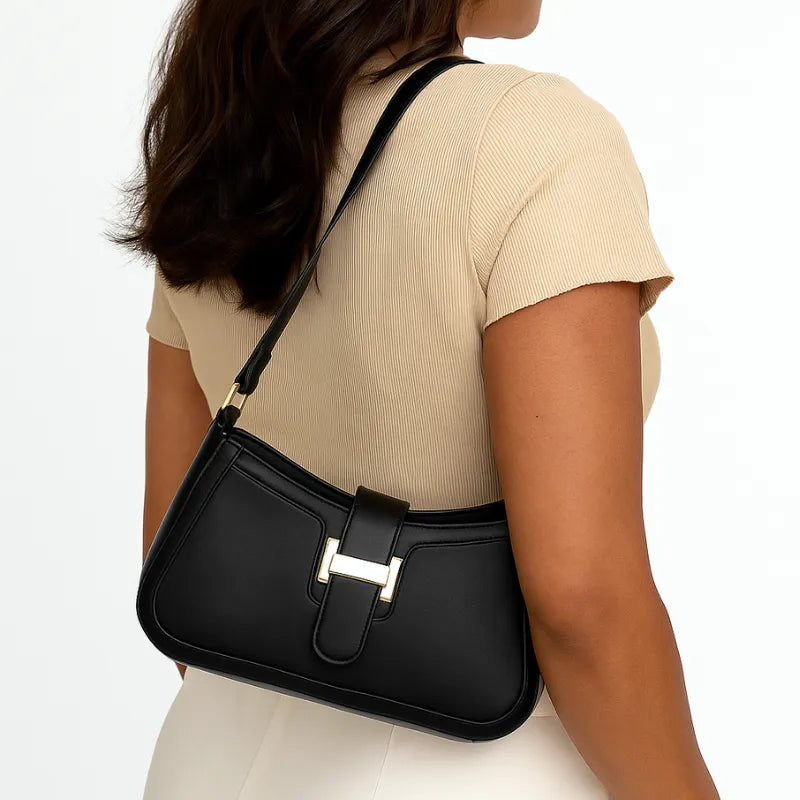 Modelo usando a bolsa de ombro preta. A imagem realça o estilo elegante e a alça de ombro, ideal para o dia a dia.
