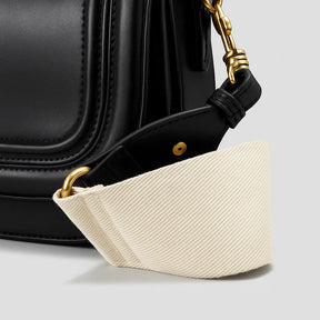 Detalhe da alça grossa removível da bolsa de ombro Florence da Rozze. A foto aproxima a costura de alta qualidade e o acabamento em couro PU preto.