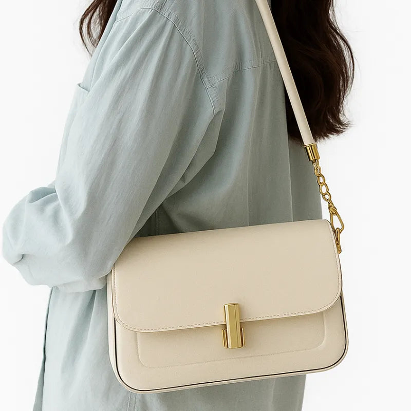 Modelo usando a bolsa retangular branca no ombro. A imagem realça o estilo elegante e o tamanho compacto do acessório.