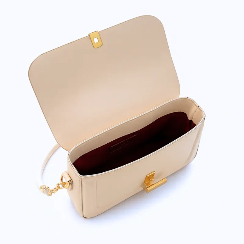 Vista superior da bolsa retangular branca aberta. A foto revela o interior e o fecho metálico, mostrando a funcionalidade do acessório.