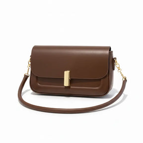 Bolsa retangular marrom em vista lateral. A foto exibe a forma do acessório e a combinação da alça curta com a alça de corrente.