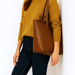 Modelo usando a bolsa tote caramelo em vista frontal. A foto realça a praticidade do acessório para o dia a dia e o material em Couro PU.