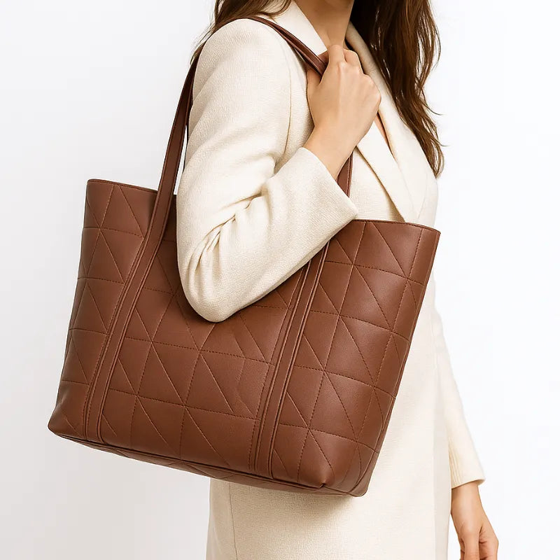 Modelo usando a bolsa tote marsala. A imagem mostra o acessório sendo carregado no ombro, realçando seu tamanho e a elegância casual.