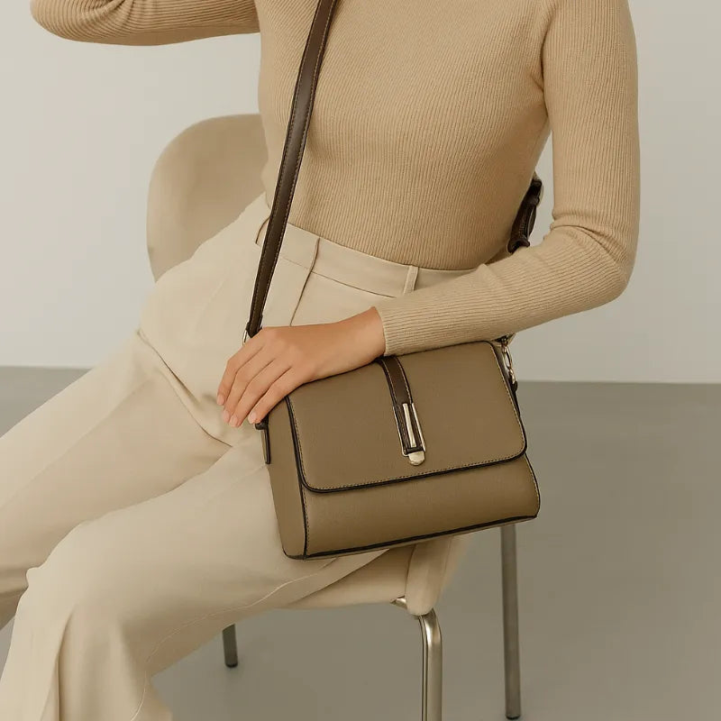 Bolsa transversal bege Gusure Luxuosa sendo usada por uma mulher em pé com pose elegante, mostrando sofisticação.