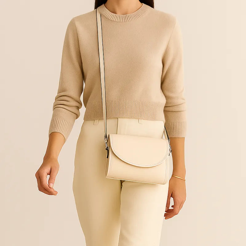 Bolsa transversal branca Stella Maris sendo segurada por uma mulher em pose frontal, destacando estilo versátil.