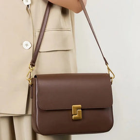 Modelo usando a bolsa transversal Prestige, em pé. A imagem realça o caimento da bolsa no corpo, o material em couro legítimo e o estilo sofisticado.