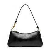 Vista superior da bolsa de ombro baguete preta aberta. A foto revela o interior com forro claro, bolsos internos e o fechamento por zíper.