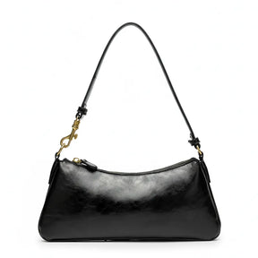 Vista superior da bolsa de ombro baguete preta aberta. A foto revela o interior com forro claro, bolsos internos e o fechamento por zíper.