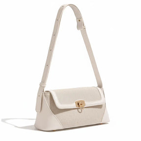 Bolsa de ombro bege canvas em vista lateral. A imagem realça a alça ajustável e a estrutura compacta do acessório.