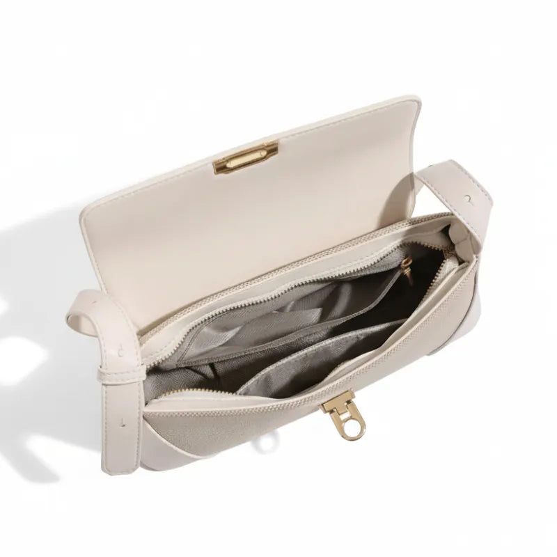Vista superior da bolsa de ombro bege aberta. A foto revela o interior forrado e a organização interna para itens essenciais.