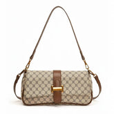 Bolsa de ombro feminina, vista frontal em estúdio. A foto destaca o canvas bege com monograma e a aba de fecho marrom.