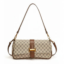 Bolsa de ombro feminina, vista frontal em estúdio. A foto destaca o canvas bege com monograma e a aba de fecho marrom.