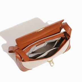 Vista superior da bolsa de ombro canvas aberta. A foto revela o interior organizado e o mecanismo da trava.