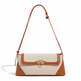 Bolsa de ombro feminina bicolor em canvas e marrom, vista frontal. A foto destaca a trava dourada giratória e o design estruturado.