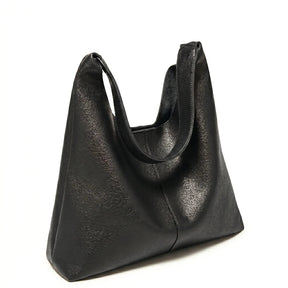 Bolsa feminina hobo preta em couro texturizado em close na textura do material, com padrão e costuras visíveis