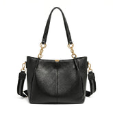 Bolsa hobo preta com corrente dourada em vista frontal, com formato, alça e ferragens visíveis, sobre fundo claro