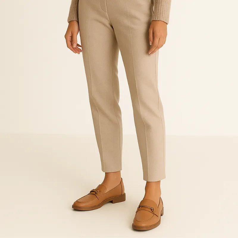 Loafer marrom feminino Deluxe sendo usado por uma mulher em pé com pose casual, mostrando conforto.