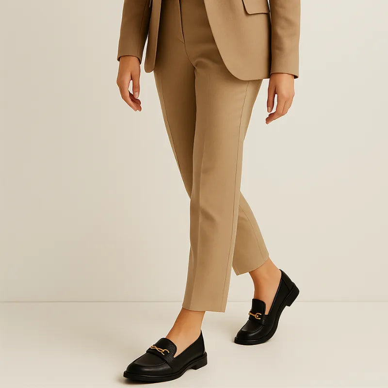 Loafer preto feminino com fivela sendo usado por uma mulher sentada com pose elegante, exibindo estilo
