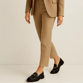 Loafer preto feminino com fivela sendo usado por uma mulher sentada com pose elegante, exibindo estilo