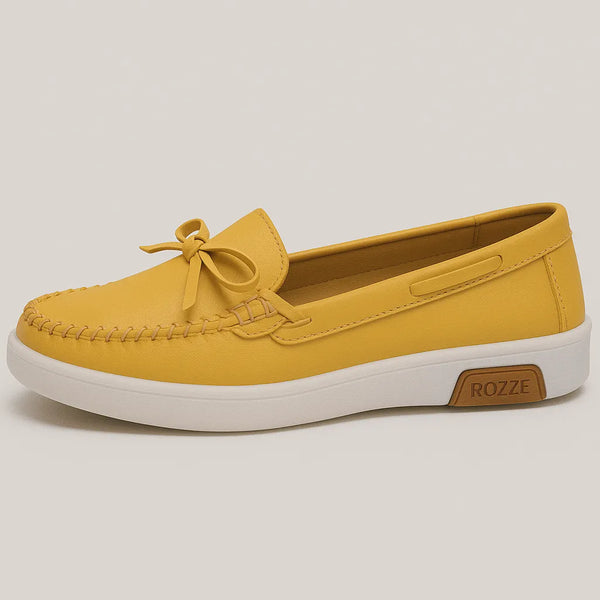 Mocassim amarelo com laço, vista frontal, destacando design moderno com laço decorativo e sola antiderrapante.