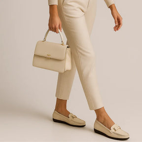 Modelo usando o mocassim branco de couro da Rozze, em pé. A foto de perfil realça a praticidade do design slip-on e a leveza do calçado.