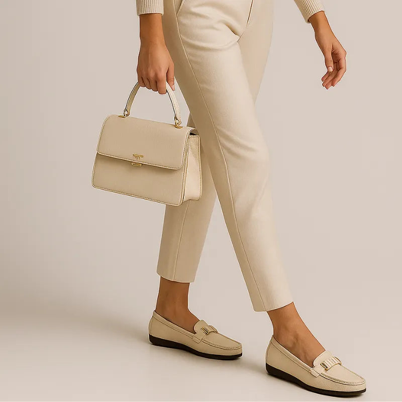 Modelo usando o mocassim branco de couro da Rozze, em pé. A foto de perfil realça a praticidade do design slip-on e a leveza do calçado.