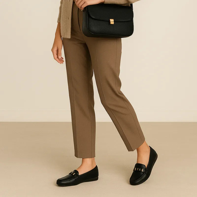 Mocassim feminino preto sendo usado por uma mulher em calça social, combinando conforto e estilo no look corporativo