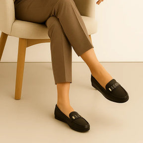 Detalhe do salto baixo (1-3cm) do mocassim feminino preto, mostrando a altura discreta e o design antiderrapante