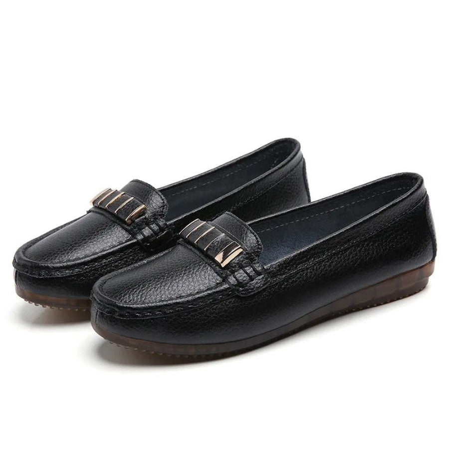 Detalhe do fecho metálico na parte superior do mocassim feminino preto, adicionando um toque de elegância ao design